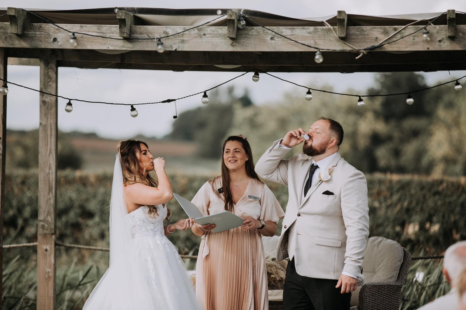 Jemma from Love Jemma officiating a wedding ceremony, where the bride and groom take a shot during their ceremony.